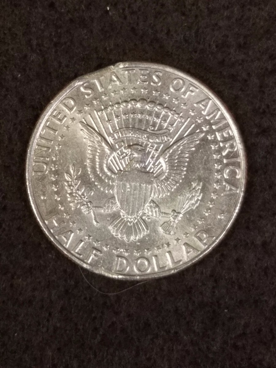 1995 Kennedy half dollar lamination flaw showing peeling clad layer and exposed copper core